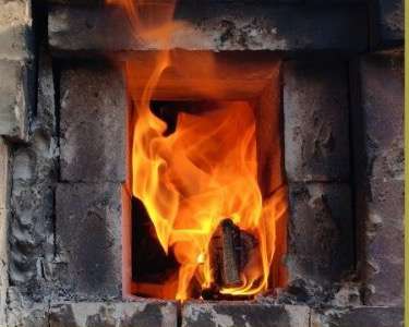 Flame rising from the firebox of the wood-fired kiln.